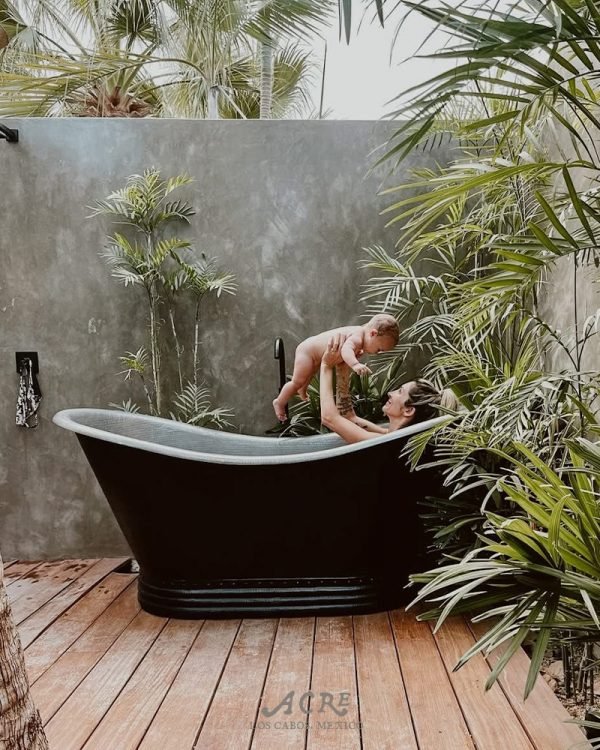 Mujer con un bebé en el jacuzzi entroncado en medio de la selva