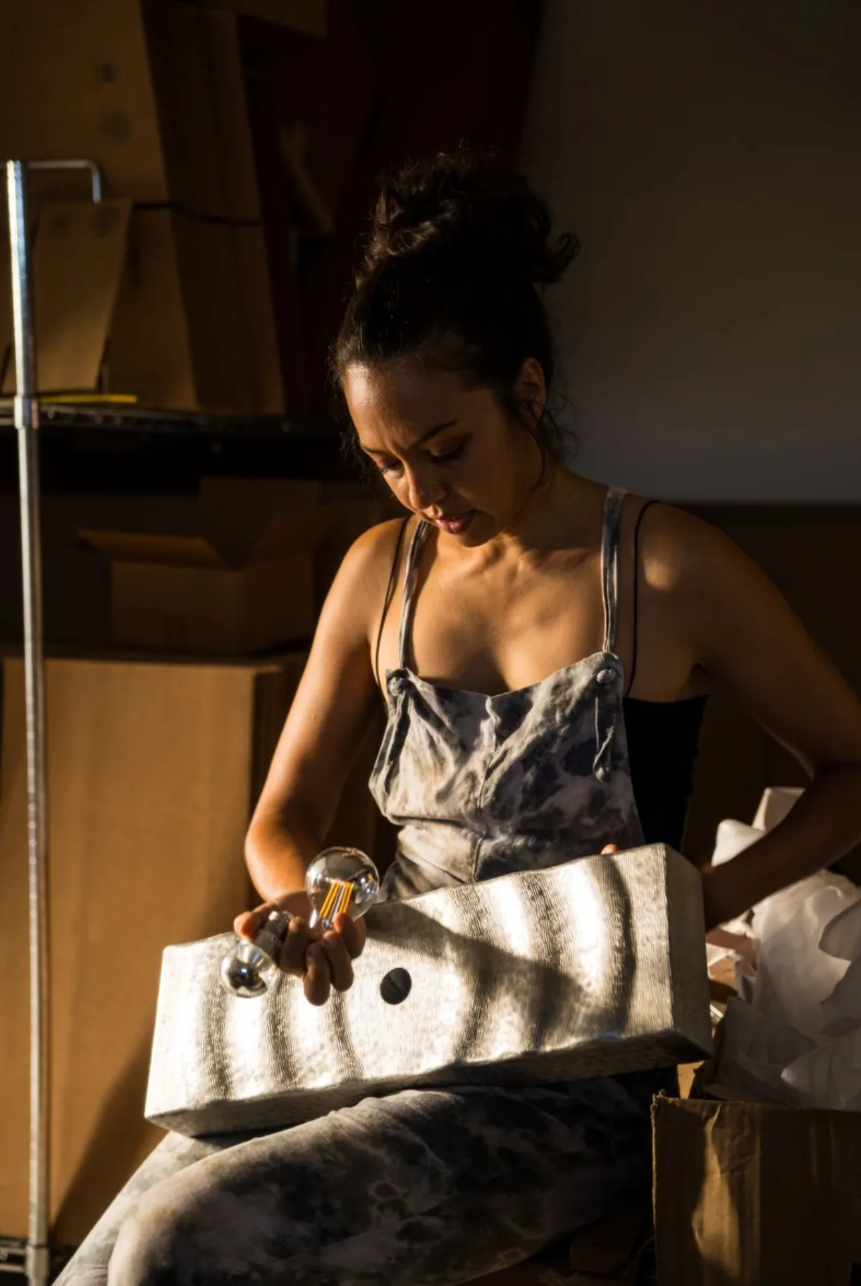 Mujer artesana trabajando con bombilla y material reciclado